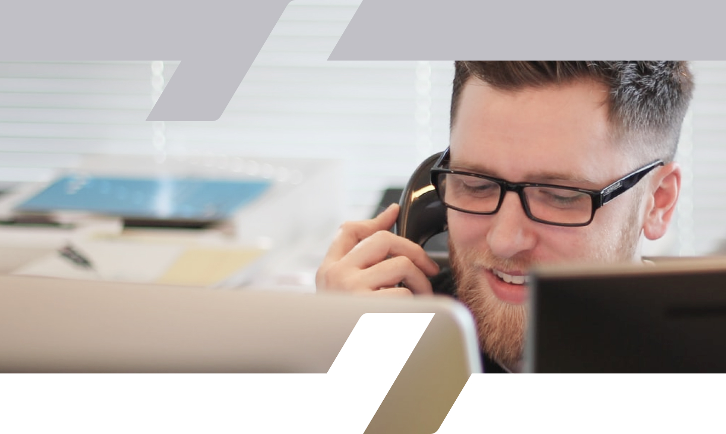 A man wearing glasses while on the telephone.