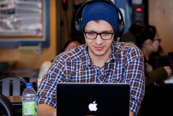 Man sat with a hat and headphones on.